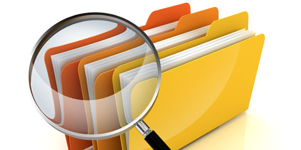 Magnifying Glass looking at File Folders representing 'HR Case Studies'
