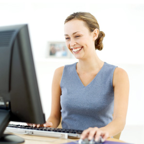 professional woman sitting at computer smiling